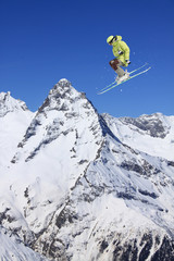 Naklejka na ściany i meble Flying skier on mountains. Extreme winter sport.