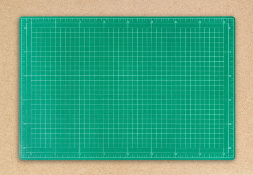 Green cutting mat on brown paper background.