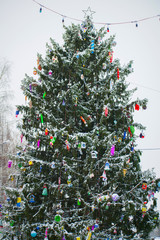 Holiday Christmas tree decorating with multi colored toys. Christmas mood on the old town square.