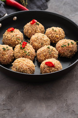 Raw meatballs in a pan on black background. Copy space.