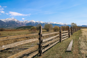 Fototapeta na wymiar Wooden fence in field on the background of the mountain Sayan
