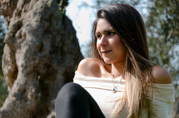 Beautiful smiling teenage girl, against green of summer.