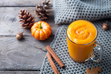 Pumpkin smoothie, latte with spices. Boozy cocktail on a wooden background. Close up.