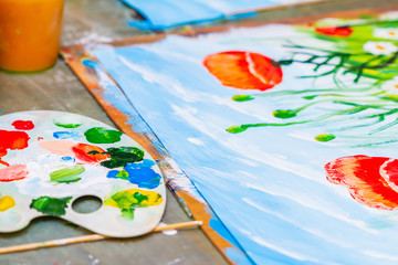 Fototapeta premium A picture painted by a child by gouache. Poppies and chamomiles. Closeup, selective focus