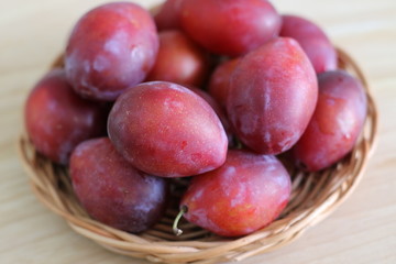 Ripe plums on straw plate