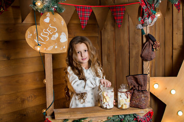 Girl near the Christmas tree. child with sweets. Christmas holidays