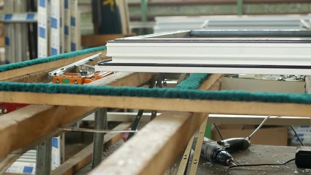 Production and manufacturing of plastic windows pvc, on the table lies the sash window, screwdriver, the shop is finished products windows