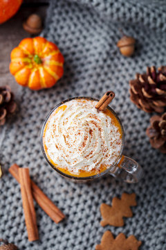 Pumpkin latte with spices and whipped cream. Grey background. Copy space. Top view.