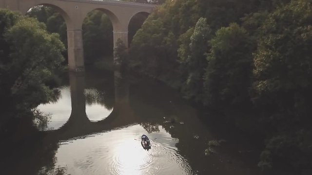 Family in blue boat on the river, footage from a drone