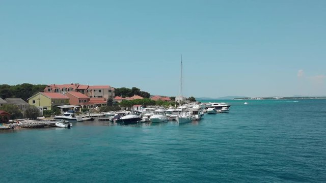 Beautiful aerial view of a small marina with boats and people swimming at the beach. Small cute island Krapanj. Croatia. Travel vacation destination. Holiday. 