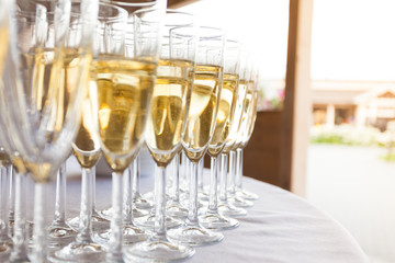 glasses with sparkling wine at an outdoor party on a sunny day