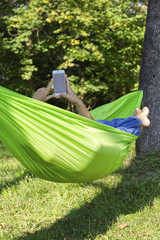 Woman relaxing on a hammock and using mobile