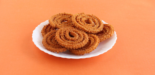 Chakli or chakkuli is a traditional, popular, vegetarian and delicious Indian savory snack, typically made during some festivals, in a ceramic plate.
