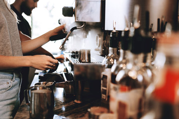 A modern expensive coffee machine is shown in work in  modern cozy coffee shop.