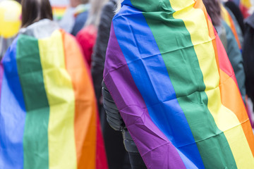 Person Carrying Rainbow Flag over Sholders in Pride Parade