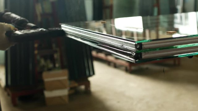 Production and manufacturing of pvc windows, the working specialist glues the glass of the double-glazed window for further assembly of the pvc window, close-up, tightness