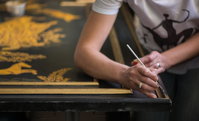 Obraz premium painter decorator draws pattern with a thin brush