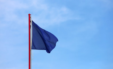 big blue flag waves on the blue sky