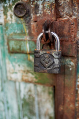 Old metallic padlock on wood, I have not painted the gate. Green shabby paint.