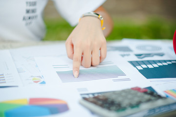 Woman sitting at desk and working at hand of book and financial documents close up