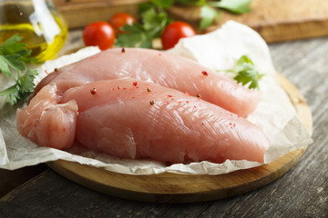 Chicken fillet, uncooked on the rustic desk with other ingredients