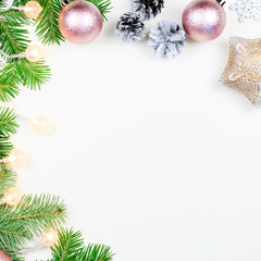 Christmas background with fir tree branches, Christmas lights, pink and beige decorations, silver ornaments