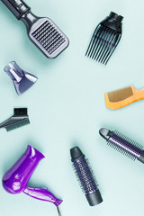 Hairdressing tools with flowers on blue wooden background