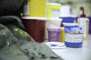 verschiedene farbbecher und stoff mit farbflecken