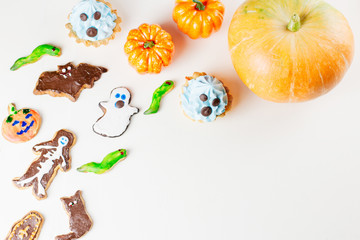 Halloween sweet treats, party food concept. Scary cookies, monster biscuits and fruits on white background.