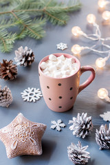 Obraz na płótnie Canvas Winter background with hot drink with marshmallows, Christmas lights, fir tree and decorations.