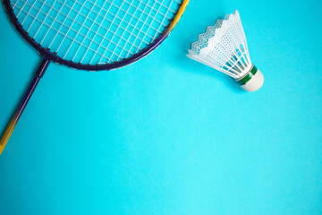 Close up shuttlecock and badminton racket on blue background.
