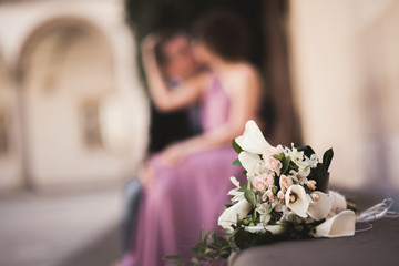 Wedding flowers bouquet with newlywed couple on background