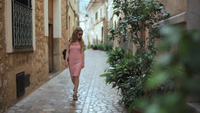 Woman walks through narrow alley of Soller in Mallorca, Spain