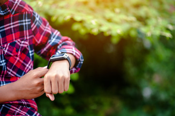 Hands and digital watches of boys Watch the time in the wrist. The orientation is punctual.