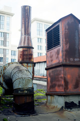 Naklejka premium Old rusty vents on the roof of an abandoned building. Rust