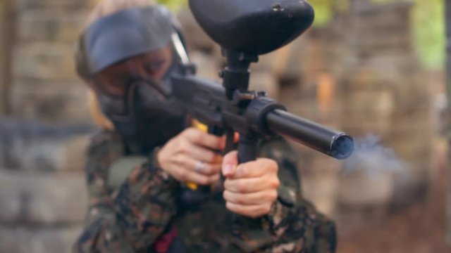 Man in camouflage with gun hitting at target
