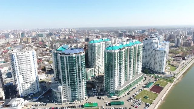 Top view: skyscrapers and river in city Krasnodar Kuban Park. Aerial panoramic shot of Krasnodar cityscape from river area on a cloudy day, Russia, skyline. Aero cityscape with downtown buildings.