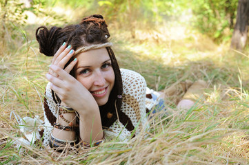 Boho style smiling woman portrait, girl have a fun lying outdoor in autumn sunny park