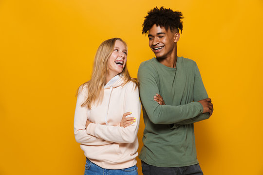 Photo of teenage people man and woman 16-18 with dental braces smiling, isolated over yellow background