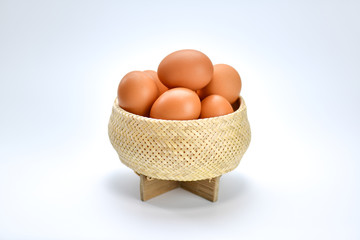 Brown eggs in the basket on a white background.