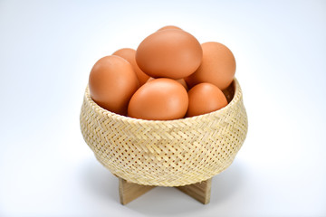 Brown eggs in the basket on a white background.