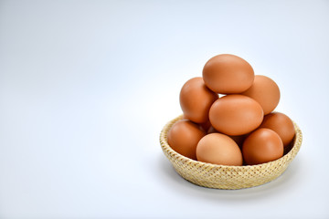 Brown eggs in the basket on a white background.
