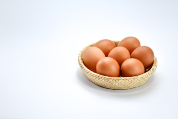 Brown eggs in the basket on a white background.