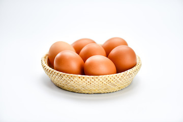 Brown eggs in the basket on a white background.