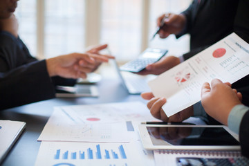 Close up of hands and stationery of Business people counting on calculator sitting at the table.