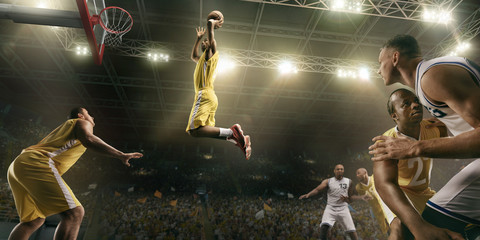 Basketball players on big professional arena during the game. Basketball player makes slum dunk