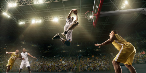 Basketball players on big professional arena during the game. Basketball player makes slum dunk