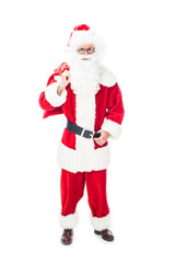 smiling santa claus in eyeglasses holding christmas sack over shoulder isolated on white background