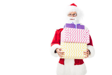 happy santa claus in eyeglasses holding pile of christmas presents isolated on white background