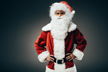 confident santa claus in costume standing with hands on waist isolated on grey background